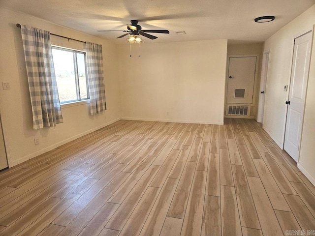 unfurnished room with light wood-style flooring, visible vents, ceiling fan, and baseboards