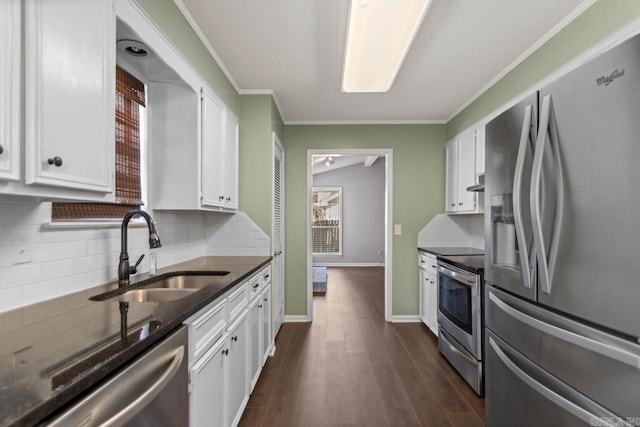 kitchen featuring dark wood-type flooring, stainless steel appliances, crown molding, white cabinetry, and a sink