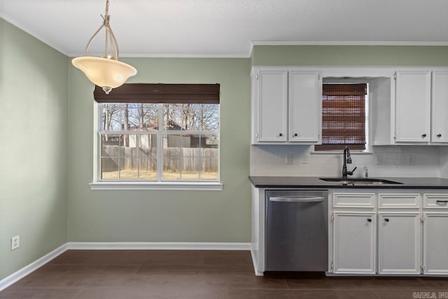 kitchen featuring dishwasher, dark countertops, a sink, and white cabinetry