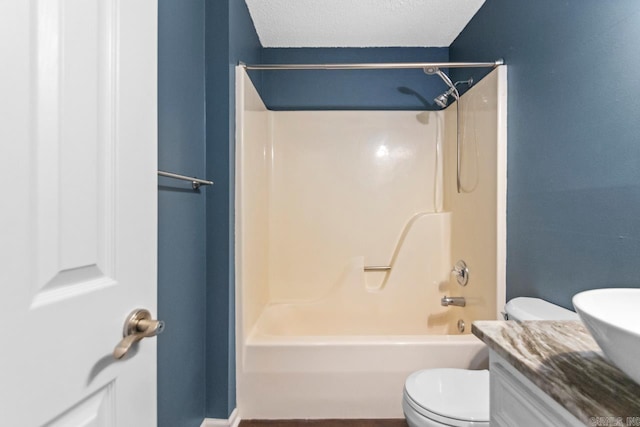 full bath with a textured ceiling, shower / bathing tub combination, vanity, and toilet