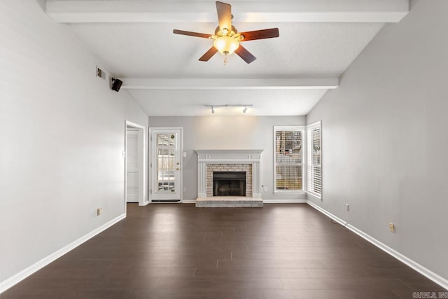 unfurnished living room with visible vents, a fireplace, dark wood-style floors, and a wealth of natural light