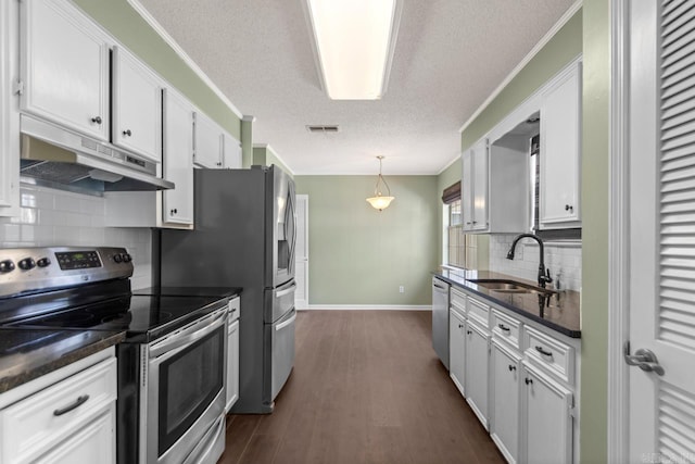 kitchen featuring stainless steel appliances, dark countertops, visible vents, a sink, and under cabinet range hood