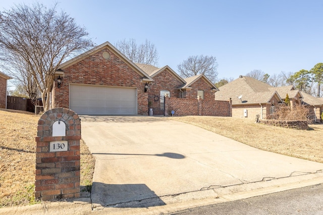 view of front of house with concrete driveway, brick siding, an attached garage, and fence