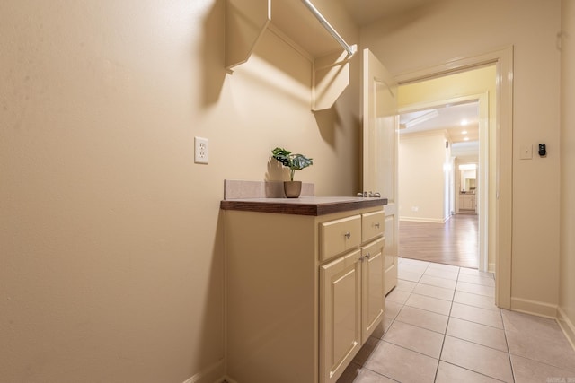 hall featuring light tile patterned floors and baseboards