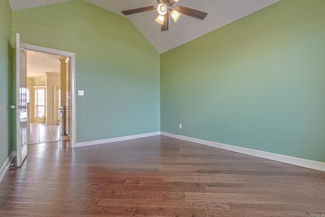 spare room featuring dark wood-style floors, ceiling fan, high vaulted ceiling, and baseboards