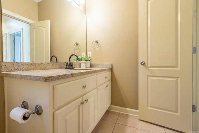 bathroom with vanity, baseboards, and tile patterned floors