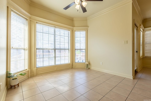 unfurnished room featuring a ceiling fan, crown molding, baseboards, and light tile patterned floors