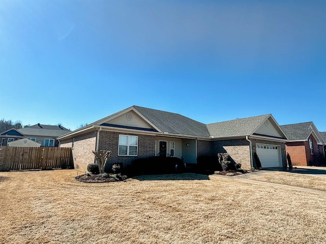 ranch-style house featuring a garage, fence, a front lawn, and brick siding