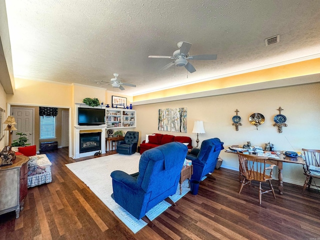2407 Brittany, Searcy, AR 72143 - living area with ceiling fan, a textured ceiling, wood finished floors, visible vents, and a glass covered fireplace