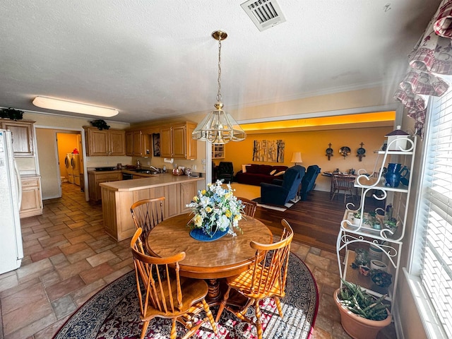 2407 Brittany, Searcy, AR 72143 - dining space with visible vents, a textured ceiling, stone tile flooring, and crown molding