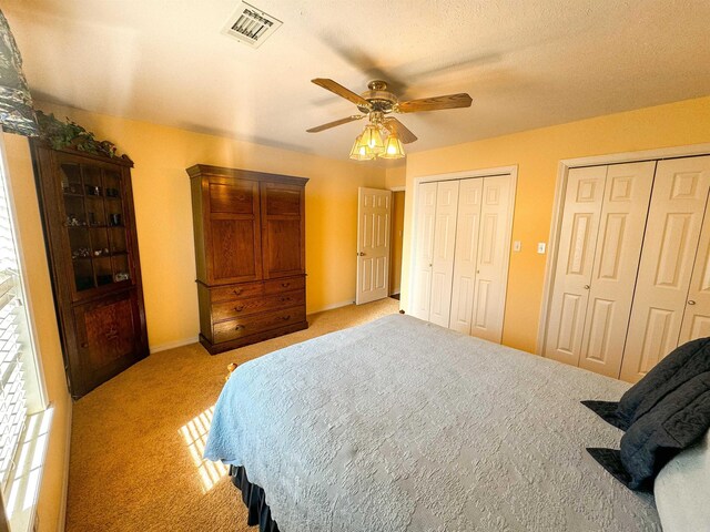 2407 Brittany, Searcy, AR 72143 - bedroom with multiple closets, light colored carpet, visible vents, and ceiling fan
