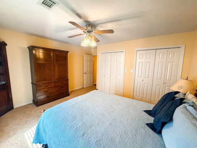 2407 Brittany, Searcy, AR 72143 - bedroom with light carpet, a ceiling fan, visible vents, and two closets