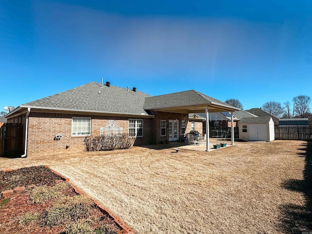 2407 Brittany, Searcy, AR 72143 - back of house with an outbuilding, a patio, a shingled roof, brick siding, and a storage unit