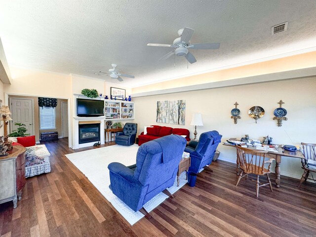 2407 Brittany, Searcy, AR 72143 - living area featuring a glass covered fireplace, wood finished floors, visible vents, and a ceiling fan