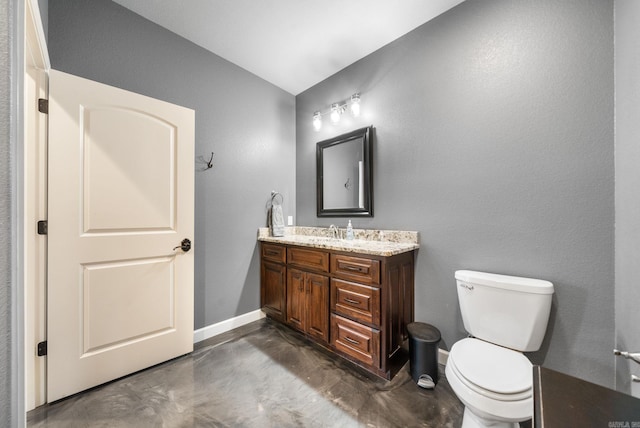 bathroom with concrete flooring, vanity, toilet, and baseboards