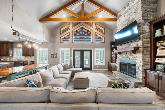 living room with a healthy amount of sunlight, light wood-style floors, a fireplace, and french doors