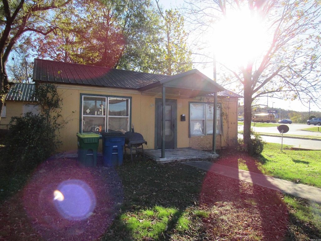 view of front of house with covered porch, metal roof, and stucco siding