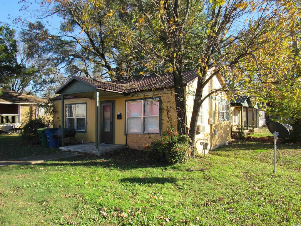 view of front of property featuring metal roof and a front yard