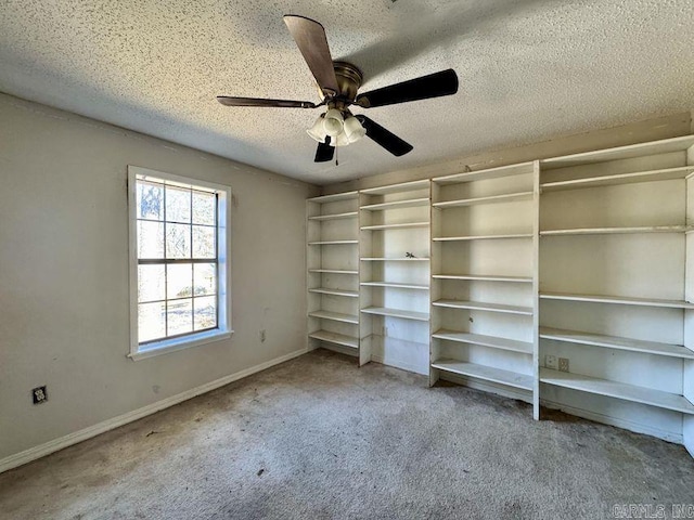 unfurnished bedroom featuring a ceiling fan, carpet, a textured ceiling, and baseboards