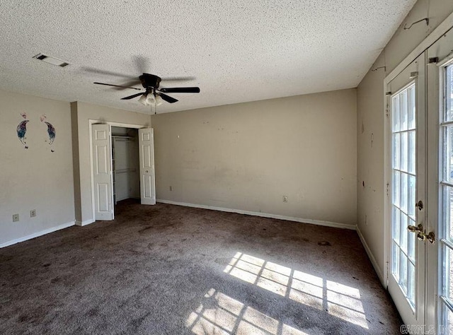 unfurnished bedroom featuring carpet floors, visible vents, a textured ceiling, and baseboards