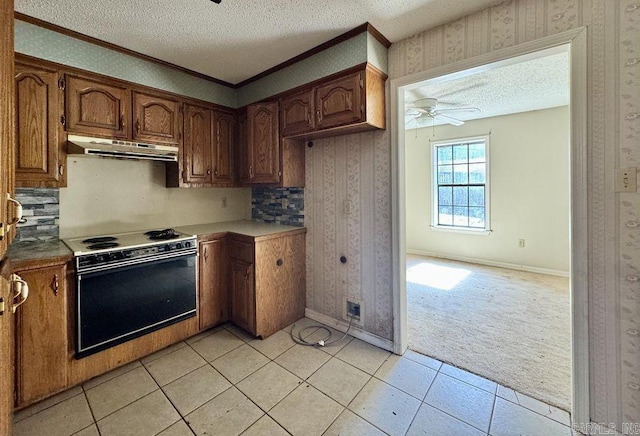 kitchen featuring electric range oven, wallpapered walls, a textured ceiling, and under cabinet range hood