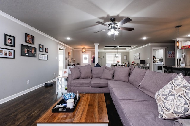 living area with baseboards, ornamental molding, dark wood finished floors, and a ceiling fan