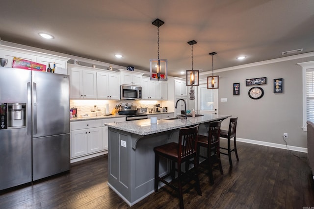 kitchen featuring light stone counters, dark wood-style floors, visible vents, appliances with stainless steel finishes, and white cabinetry