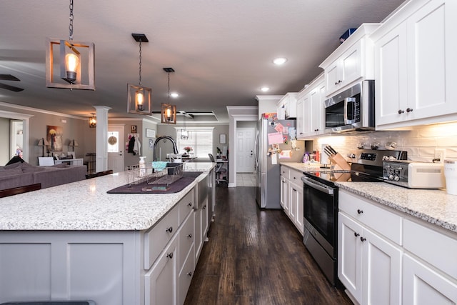 kitchen with tasteful backsplash, white cabinets, appliances with stainless steel finishes, open floor plan, and dark wood-style flooring