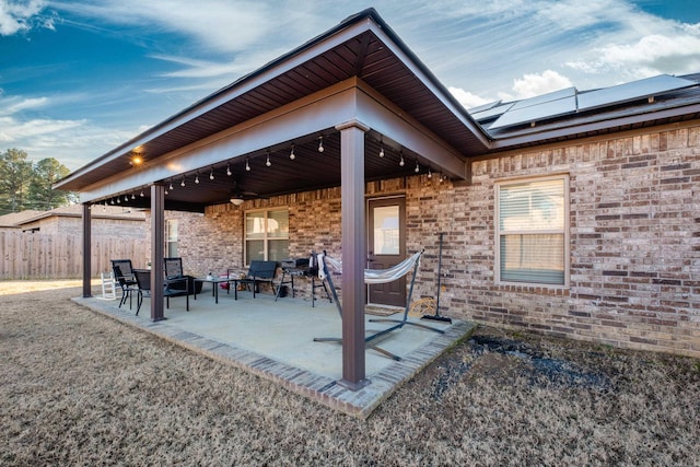 view of patio featuring fence and ceiling fan