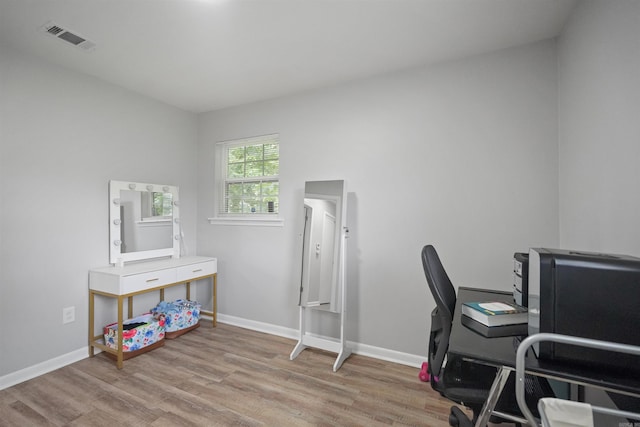 office featuring baseboards, visible vents, and wood finished floors