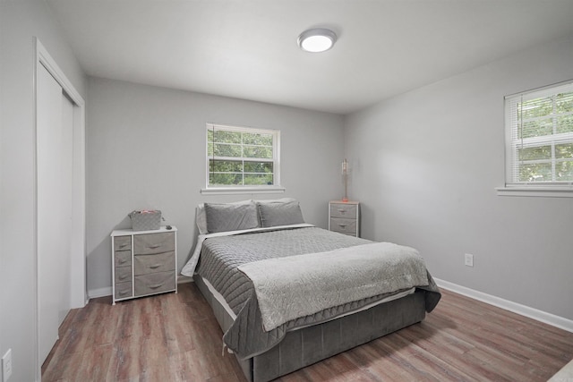 bedroom with a closet, baseboards, and wood finished floors