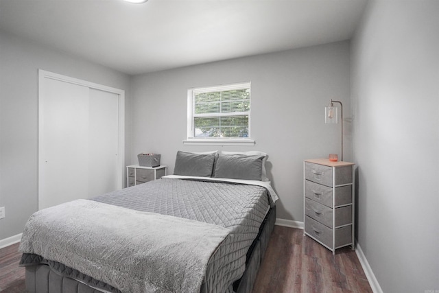 bedroom featuring a closet, dark wood finished floors, and baseboards