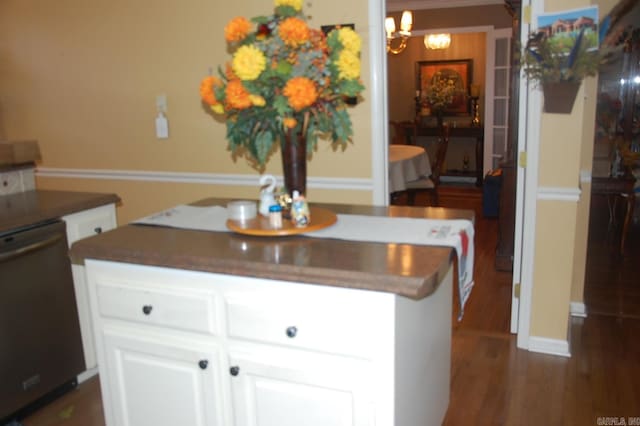 kitchen with dark wood-style flooring, an inviting chandelier, white cabinetry, a kitchen island, and dishwashing machine