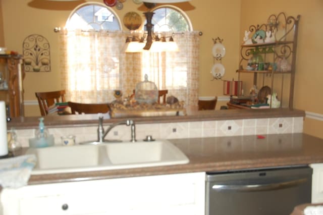 kitchen with a sink, white cabinetry, and stainless steel dishwasher