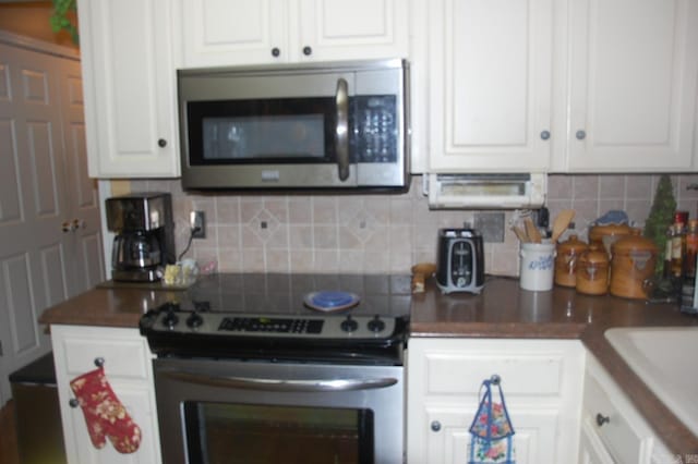 kitchen featuring white cabinetry, tasteful backsplash, appliances with stainless steel finishes, and a sink