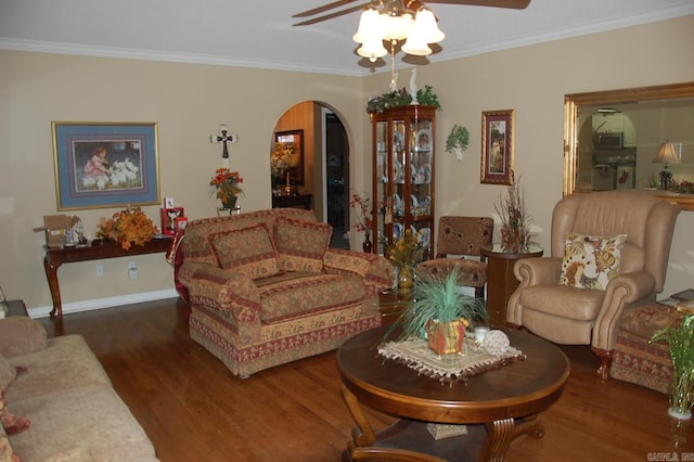 living room with baseboards, arched walkways, ceiling fan, ornamental molding, and wood finished floors