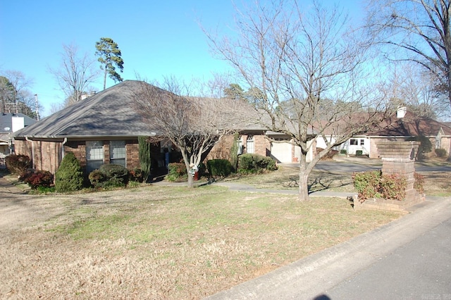 ranch-style home featuring brick siding, a front lawn, and a shingled roof