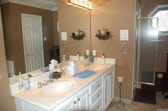 bathroom featuring double vanity, a stall shower, ornamental molding, and a sink