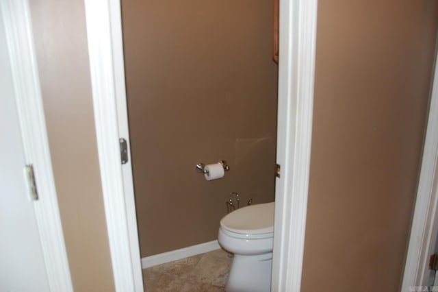 bathroom featuring toilet, tile patterned flooring, and baseboards