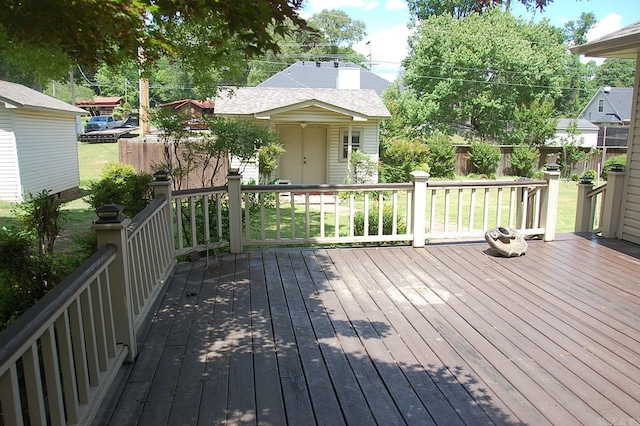 deck featuring an outdoor structure, fence, and a yard