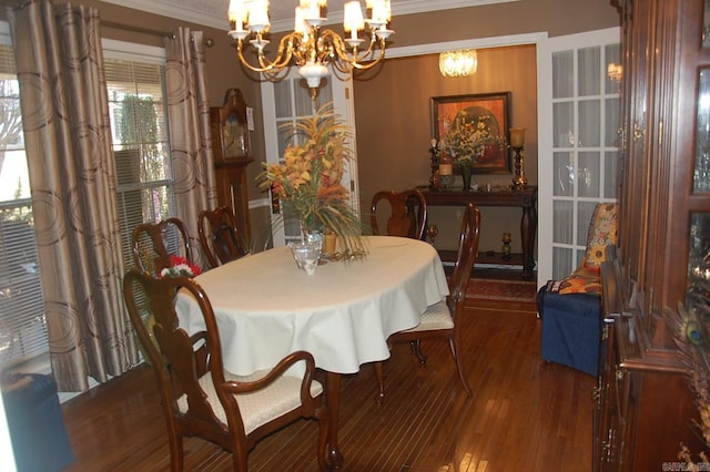 dining area with crown molding, an inviting chandelier, and wood finished floors