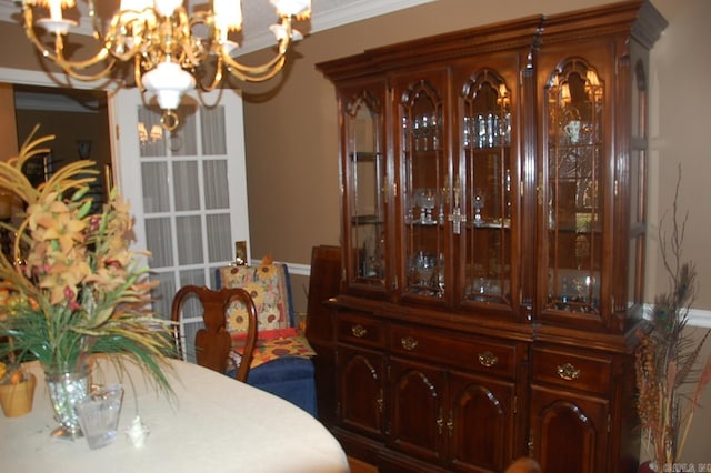 dining area featuring crown molding and a notable chandelier