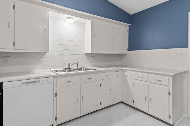 kitchen featuring white dishwasher, white cabinets, a sink, and light countertops