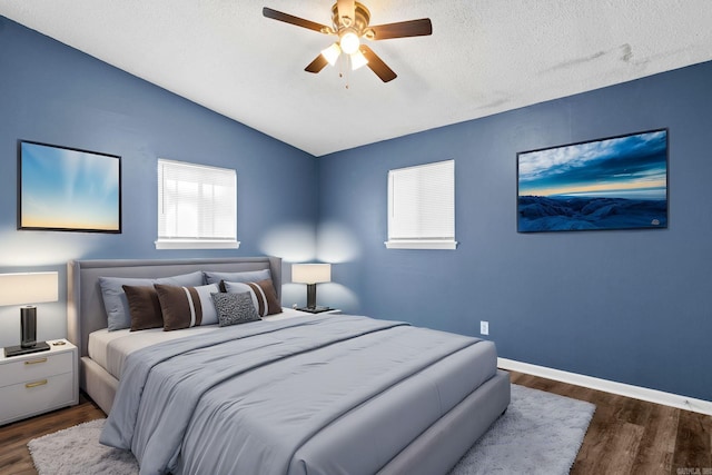 bedroom featuring ceiling fan, a textured ceiling, baseboards, vaulted ceiling, and dark wood-style floors