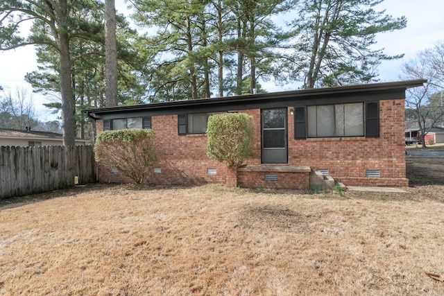 ranch-style house with a front yard, crawl space, brick siding, and fence