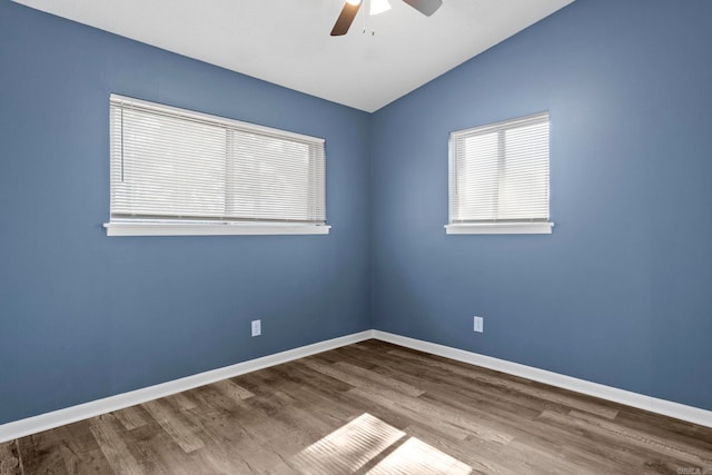 spare room with a ceiling fan, lofted ceiling, baseboards, and wood finished floors