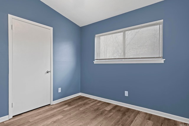 empty room with baseboards and wood finished floors