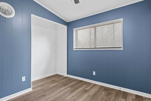 spare room with a ceiling fan, baseboards, ornamental molding, and wood finished floors