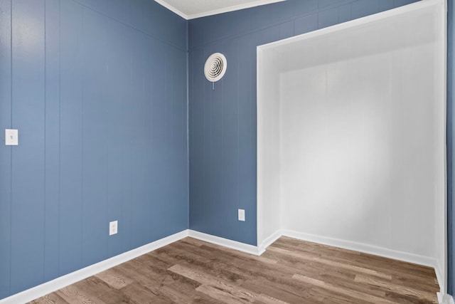 spare room with crown molding, dark wood finished floors, visible vents, and baseboards