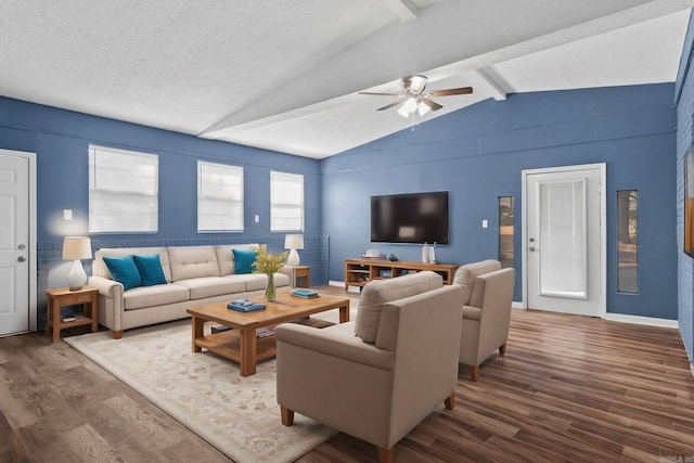 living area with a ceiling fan, lofted ceiling with beams, baseboards, and wood finished floors